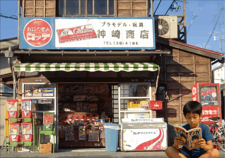 A boy reading a comic book in front of a candy store