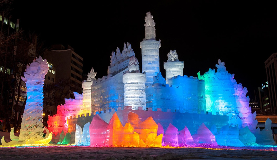 Illuminated ice and snow sculptures at the Sapporo Snow Festival’s Odori Park site at night.