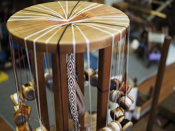 Marudai is a stand consisting of a circular mirror (top plate), legs, and base plate. It is designed so that a braided string can be hung from the hole in the center of the mirror. This stand can be used for anything from simple braiding to complex kara-gumi braiding.