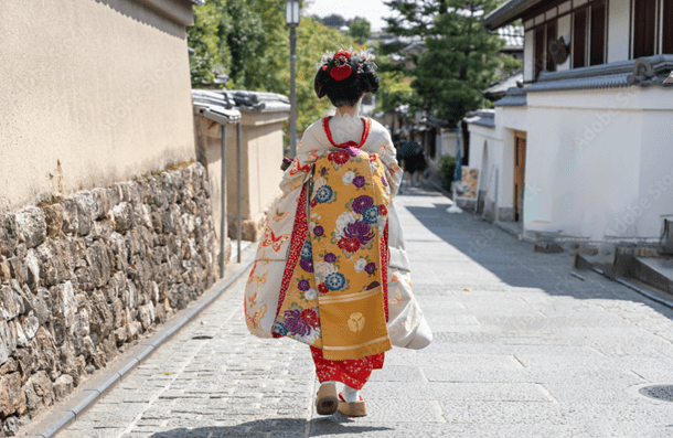 The back view of a maiko walking through the streets of Kyoto